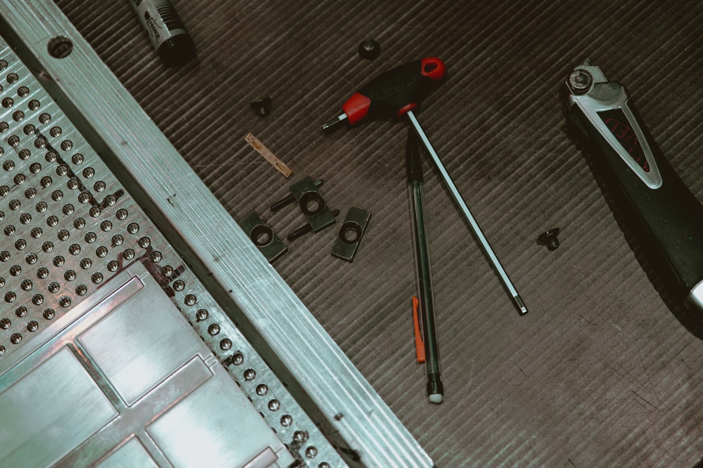 Various tools and metal components on an industrial workbench.